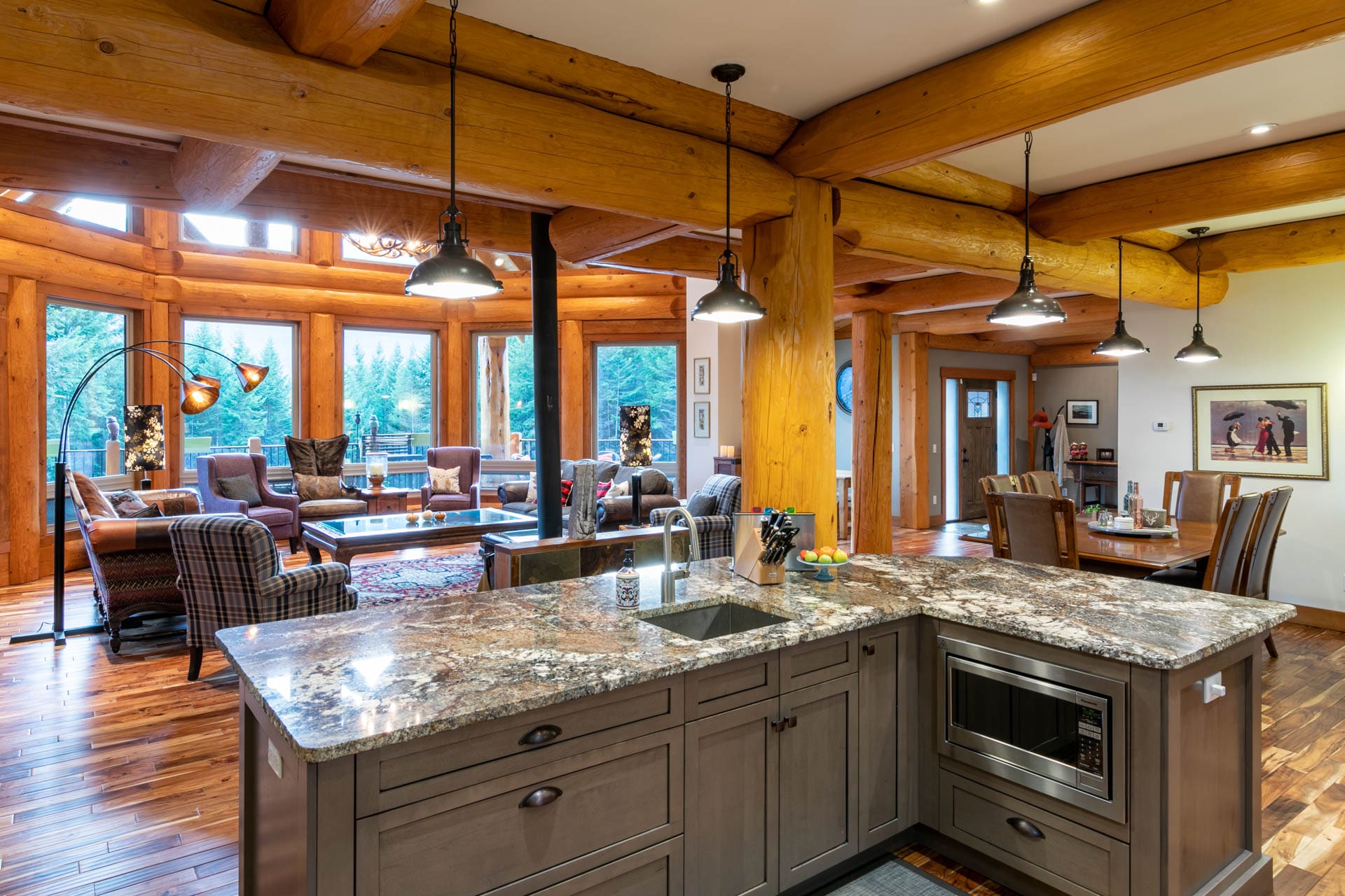 interior view of BC custom built log home of kitchen and living room view.